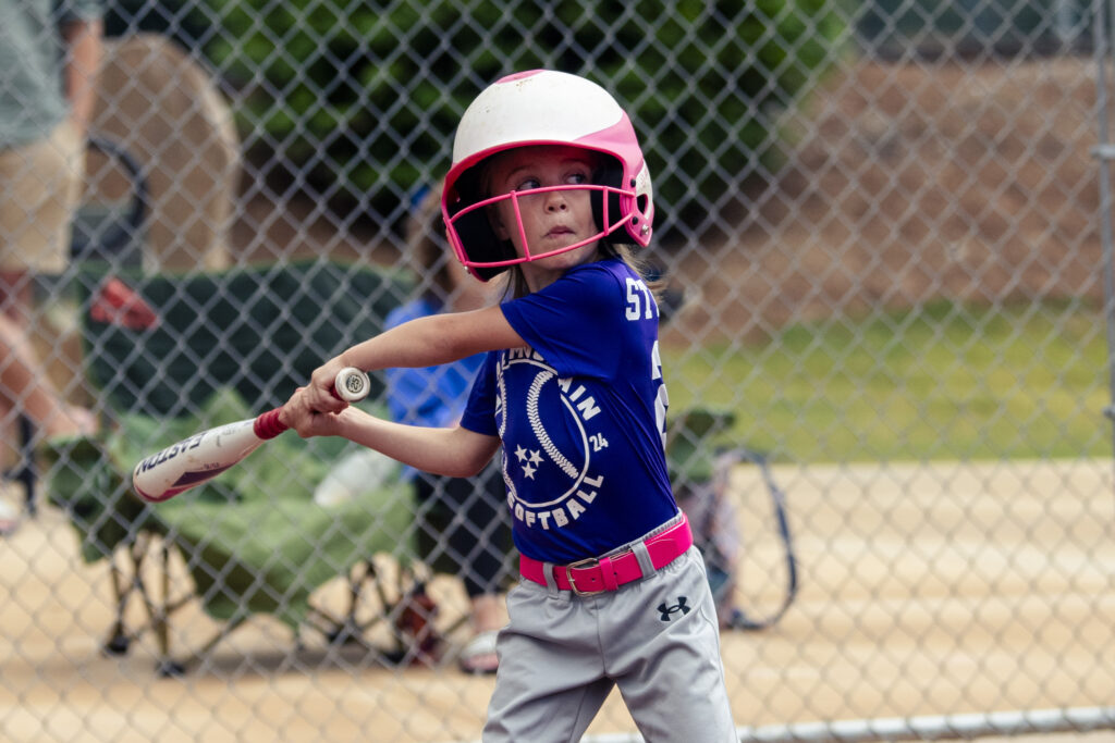 a youth softball player gets ready to swing at a pitch in a game in chattanooga