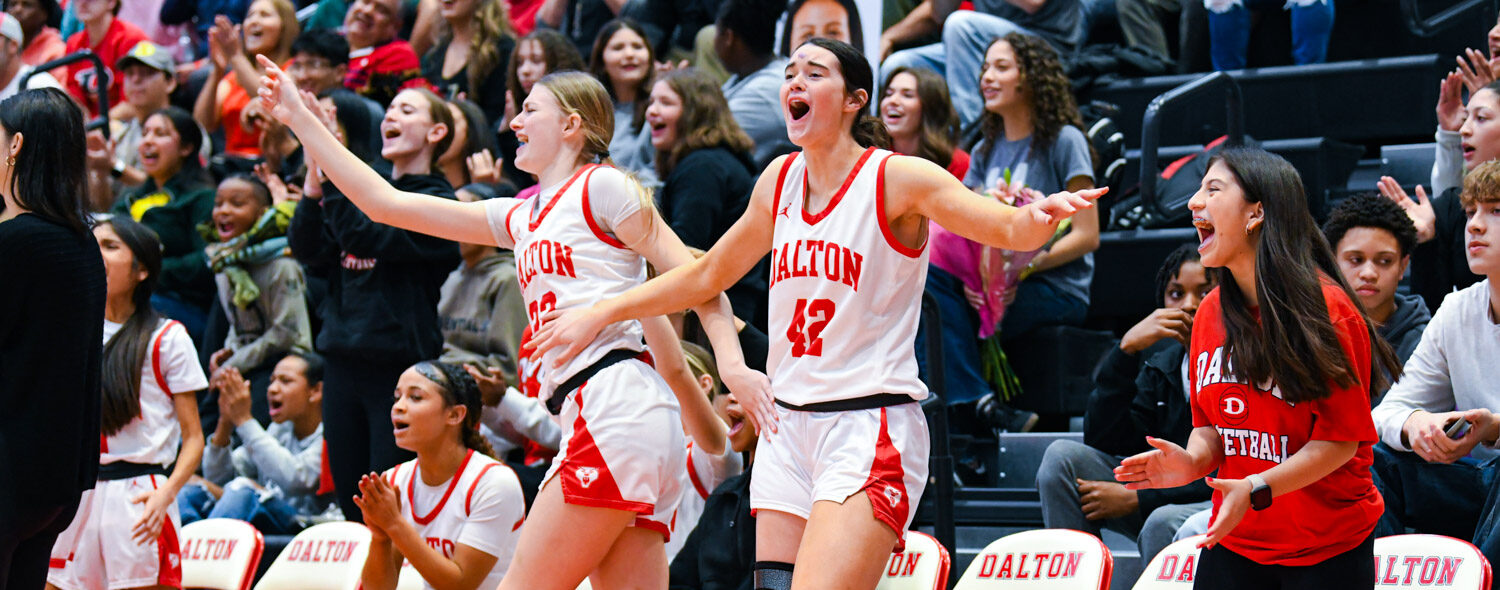 two high school basketball players react to a big play